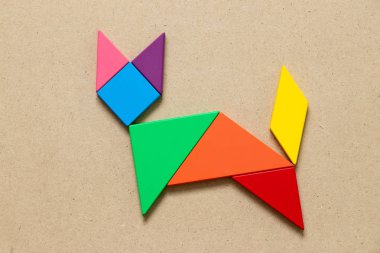 Renk tangram bulmacanın ahşap arka plan üzerinde kedi şeklinde