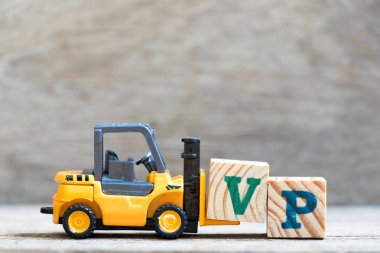 Oyuncak forklift tutun mektup blok V Word'de Vp (kısaltması Başkan Yardımcısı olan) ahşap arka plan üzerinde