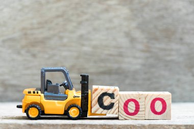 Oyuncak forklift kelime coo (COO kısaltma) ahşap zemin üzerine mektup blok c hold