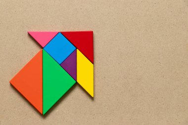 Renk tangram bulmacanın ahşap arka plan üzerinde ok şeklinde