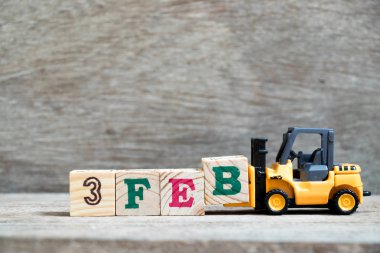 Oyuncak forklift tutun B blok ahşap arka plan (takvim tarih 3 ay Şubat için kavram üzerinde tam Word'e 3 Şubat)