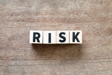 Ahşap arka plan üzerinde kelime risk bloğunda ahşap mektup