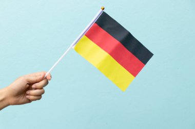 Kadın tutun Alman bayrağı üzerinde mavi arka plan