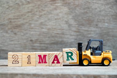 Ahşap arka plan (Konsept takvim tarih 21 Mart ayında için Word 21 mar tamamlamak için oyuncak forklift tutun blok R)