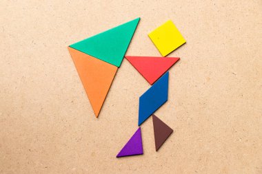 Renk tangram bulmacanın Man tutun şemsiye şekli üzerinde ahşap arka plan (kavram olarak iş vardır kriz veya sorun)