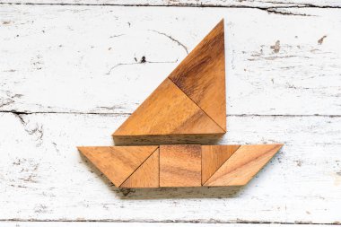 Tangram bulmacanın eski beyaz ahşap zemin üzerinde tekne veya yat şeklinde