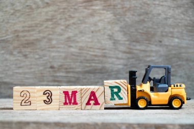 Ahşap arka plan (Konsept takvim tarihi 23 Mart ayında için Word 23 mar tamamlamak için oyuncak forklift tutun blok R)