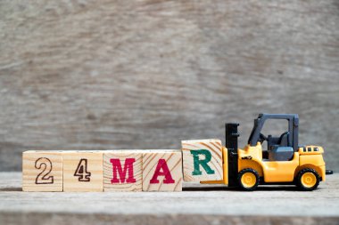 Ahşap arka plan (Konsept takvim tarihi 24 Mart ayında için Word 24 mar tamamlamak için oyuncak forklift tutun blok R)