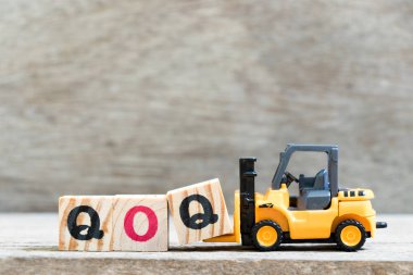 Oyuncak forklift kelime çeyreksel (çeyrek çeyrek üzerinde kısaltma) ahşap zemin üzerine mektup blok hold