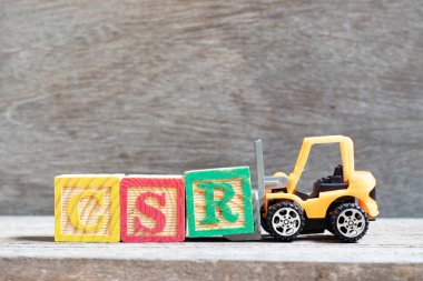 Oyuncak forklift kelime Csr (kurumsal sosyal sorumluluk kısaltma) ahşap zemin üzerine mektup blok R hold