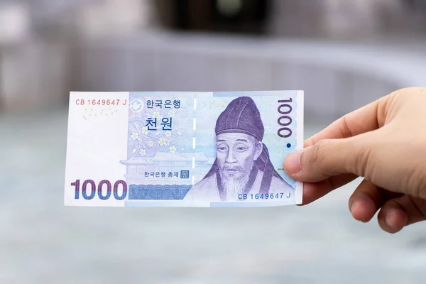 Człowiek Posiada Korea Południowa Banknot 1000 Wygrana Niewyraźne Tło — Zdjęcie stockowe