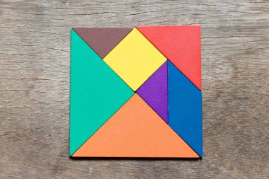 Ahşap arka plan üzerinde kare şeklinde renk tangram