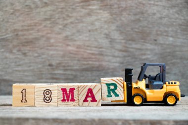 Ahşap arka plan (konsept takvim Tarih 18 Mart ayında için Word 18 mar tamamlamak için oyuncak forklift tutun blok R)
