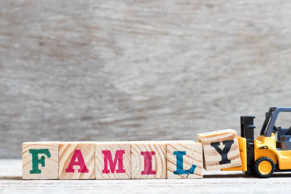 Spielzeug Gabelstapler Halten Buchstabenblock Wortfamilie Auf Holz Hintergrund Vervollständigen — Stockfoto