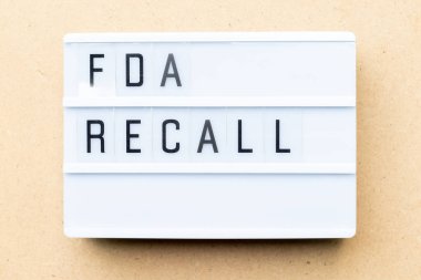 White lightbox with word fda recall on wood background clipart
