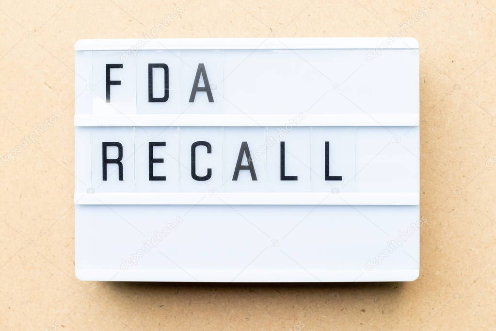 White lightbox with word fda recall on wood background