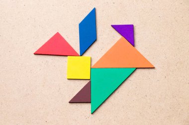 Tavşan şeklinde ahşap arka plan üzerinde renkli tangram