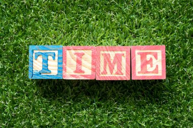 Kelime zamanlı suni çim yeşil arka plan olarak renk ahşap blok