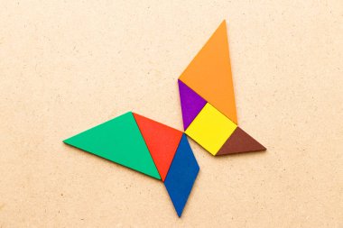 Ahşap arka plan üzerinde Kelebek şeklinde renk tangram