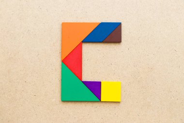 Ahşap arka plan üzerinde Alfabe harf C şeklinde bulmaca Tangram