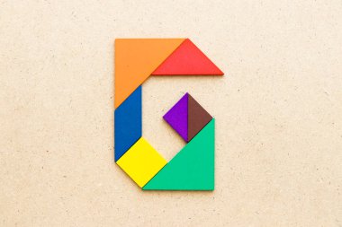 Ahşap arka plan üzerinde Alfabe harf G şeklinde bulmaca Tangram
