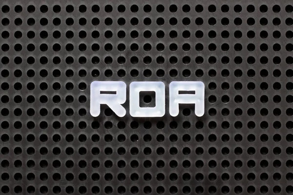 Pegboard de couleur noire avec lettre blanche dans le mot ROA (Abréviation de retour sur actifs ) — Photo