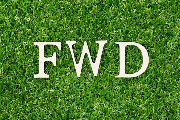 Carta de madeira na palavra FWD (abreviatura de forward) em fundo de grama verde — Fotografia de Stock