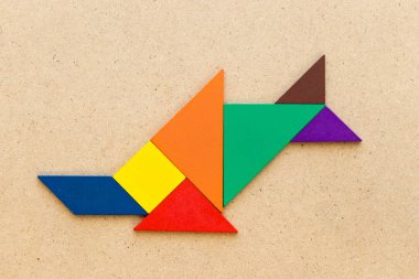 Şeklinde balık (balık ya da boynuzlu balina) ahşap arka plan üzerinde renkli tangram