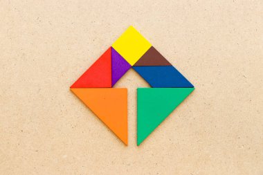 Renk tangram bulmacanın kare şekli ahşap arka plan üzerinde içinde oklu