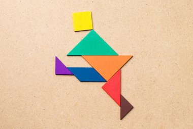 Dans veya adam şekil ahşap arka plan üzerinde tekme renk tangram
