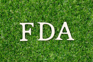 Ahşap mektup blok içinde kelime Fda (Gıda ve İlaç İdaresi kısaltma) suni yeşil çim zemin üzerine