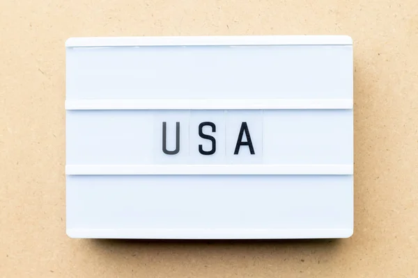 Caja de luz blanca con palabra USA (Estados Unidos de América) sobre fondo de madera — Foto de Stock