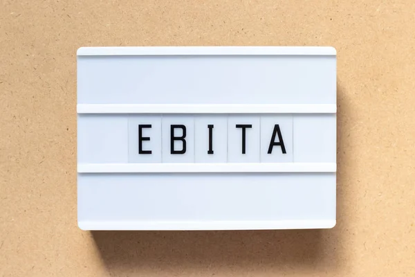 Biały lightbox z word Ebita (skrót od zarobków beforee odsetek, podatków i amortyzacji) na tle drewna — Zdjęcie stockowe