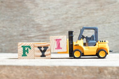 Oyuncak forklift tutun mektup ben kelime Bilginize (kısaltma, bilgin) tamamlamak için ahşap arka plan üzerinde engellemek