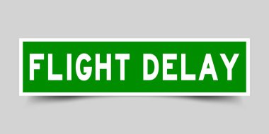 Square green sticker label in word flight delay on gray background