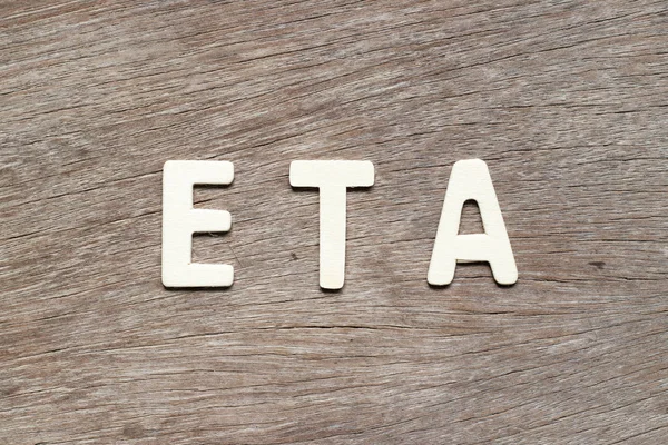 Alfabeto letra en palabra ETA (abreviatura de la hora estimada de llegada) sobre fondo de madera — Foto de Stock