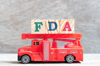 Kırmızı itfaiye kamyon kelime FDA (Gıda ve ilaç yönetiminin kısaltması) ahşap arka planda blok tutun