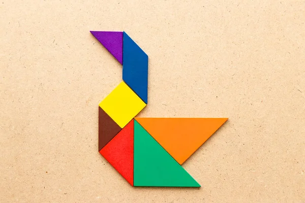 Rompecabezas tangram color en forma de cisne sobre fondo de madera —  Fotos de Stock