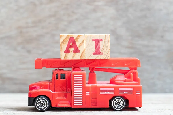 红色消防车举行信件块词 ai (页人工智能的简称) 在木头背景 — 图库照片