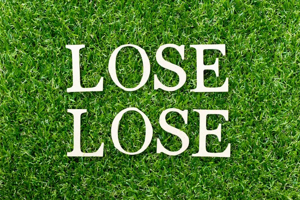Wood alphabet letter in word lose lose on green grass background