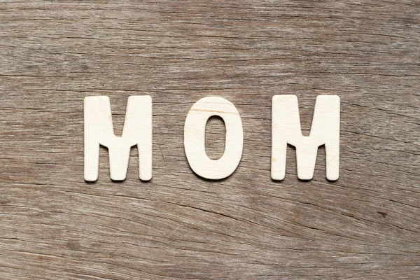 Alfabeto letra en la palabra mamá sobre fondo de madera — Foto de Stock