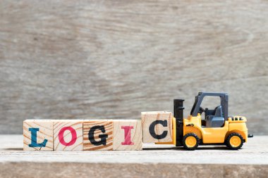 Oyuncak forklift ahşap arka plan üzerinde kelime mantığı tamamlamak için harf blok c tutun
