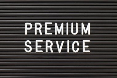 Kelime premium hizmet arka planda beyaz alfabe ile siyah renkli keçe li harf tahtası