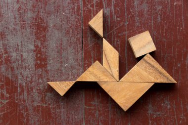 Tangram bulmacanın içinde düşen adam kırmızı eski ahşap arka plan üzerinde şekil