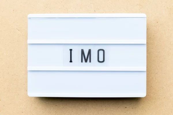 Lightbox branco com palavra IMO (Abreviatura de na minha opinião) sobre fundo de madeira — Fotografia de Stock