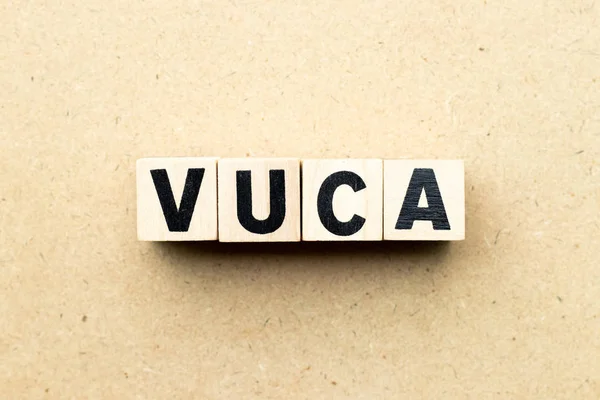 Letra bloque en la palabra VUCA (abreviatura de Volatilidad, incertidumbre, complejidad y ambigüedad) sobre fondo de madera — Foto de Stock