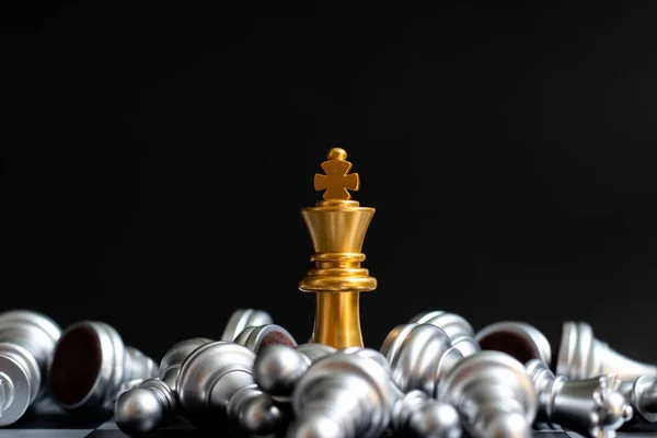 Emas raja biji catur menang atas tergeletak perak pion di latar belakang hitam — Stok Foto