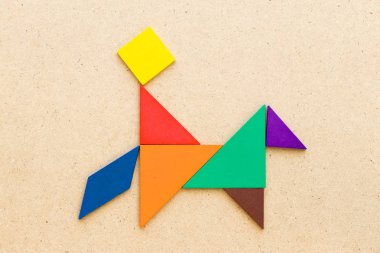 Ahşap arka planda at şeklinde adam binmek renk tangram bulmaca