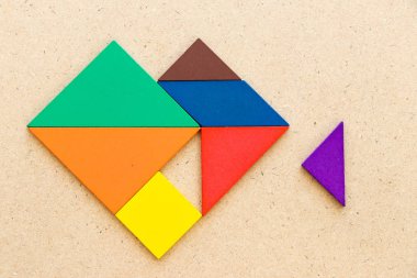 Ahşap arka plan üzerinde yerine getirmek için üçgen parça beklemek kalp şeklinde Renk tangram bulmaca