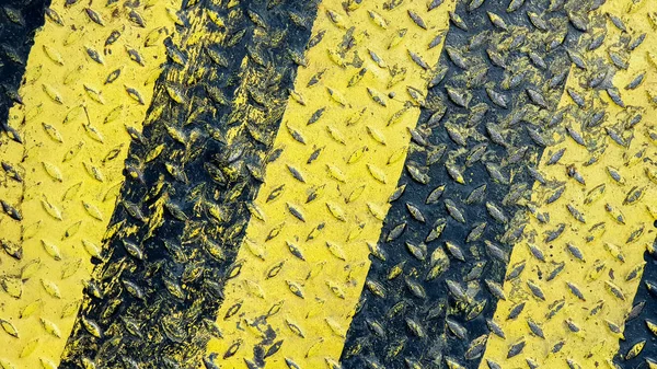 Tinta de linha preta e amarela em fundo texturizado de metal antiderrapante — Fotografia de Stock
